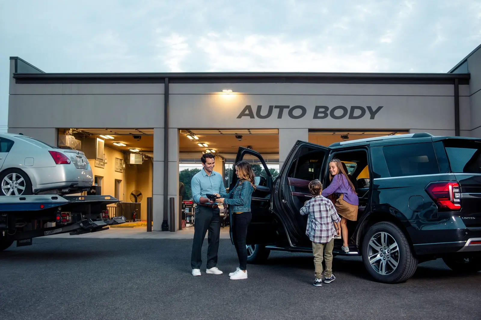 A family meets an Enterprise employee outside an auto body shop to pick up a replacement vehicle