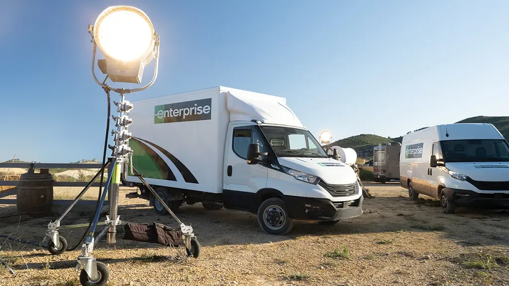 An Enterprise truck parked beside production lighting on a film set